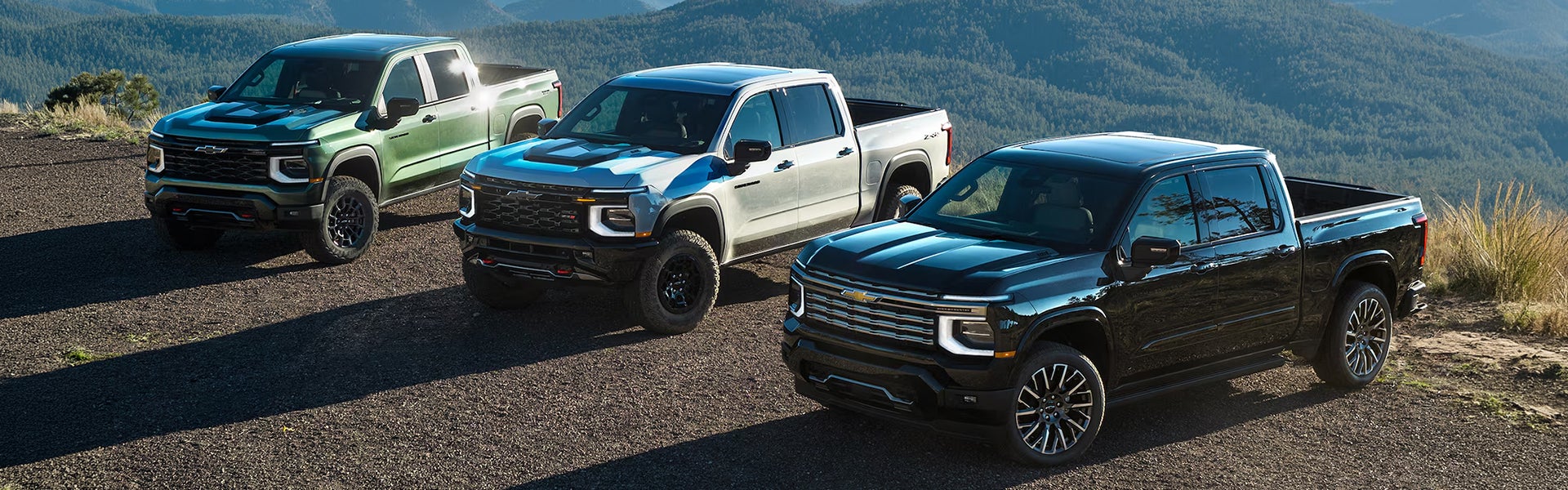 3 2027 Chevy Silverados lined up on a ridgeline.